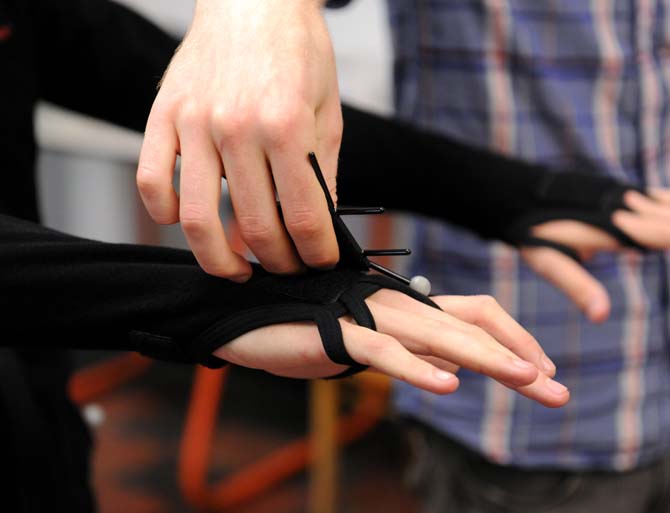 Derick Ostrenko, LSU School of Art and Center for Computation and Technology assistant professor, attaches sensors on a motion capture suit Sept. 9, 2013, at the art building.