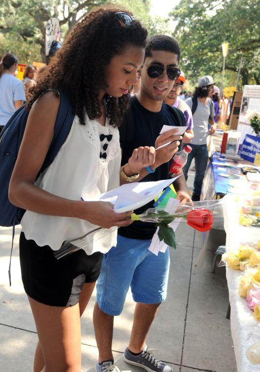 Students Maria Paula Gomez and Gustavo Gonzalez read Quran quotes handed out by the Saudi Club Wednesday, Sept. 11, 2013 at the Student Involvement Fair in Free Speech Alley.