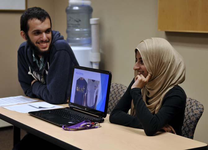 Finance grad student Izza Islam, right, and bioengineering junior Hanif Soysal, left, smile while presenting a powerpoint during the first MSA meeting of the semester on September 5, 2013 in the Acadian Room in the Union.