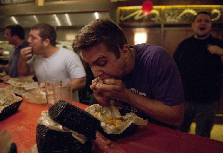 Competitor Christophe Garon chomps on tots Thursday night, Sept. 19, 2013 at Bar Louies Rock The Tot eating contest.