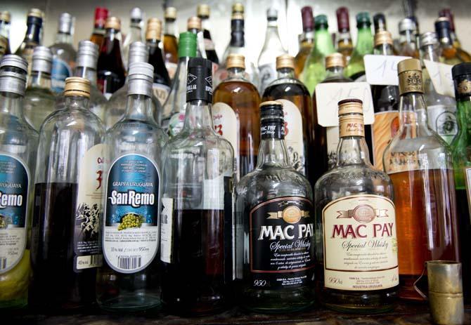 In this Aug. 21, 2013 photo, bottles of liquor line a bar shelf in downtown Montevideo, Uruguay. The government of Uruguay makes Scotch whisky. It also makes and sells rum, vodka and cognac, and has done so for nearly a century. President Jose Mujica says Uruguay&#8217;s long experience at the center of the nation&#8217;s liquor business makes it more than capable of dominating another addictive substance: marijuana. (AP Photo/Matilde Campodonico)