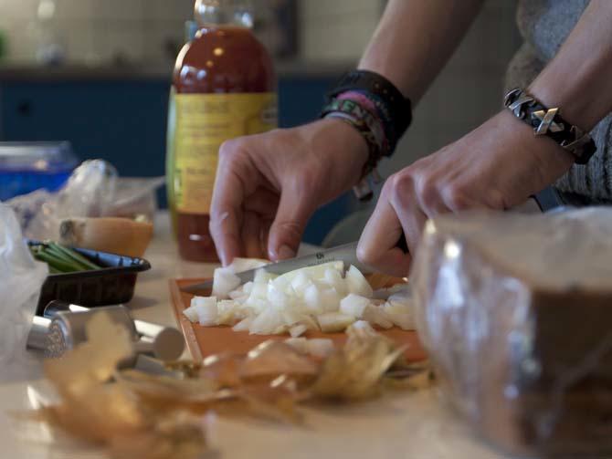 An international student chops onions for a meal Monday, Sept. 2, 2013, in a shared kitchen at Uilenstede in Amsterdam.