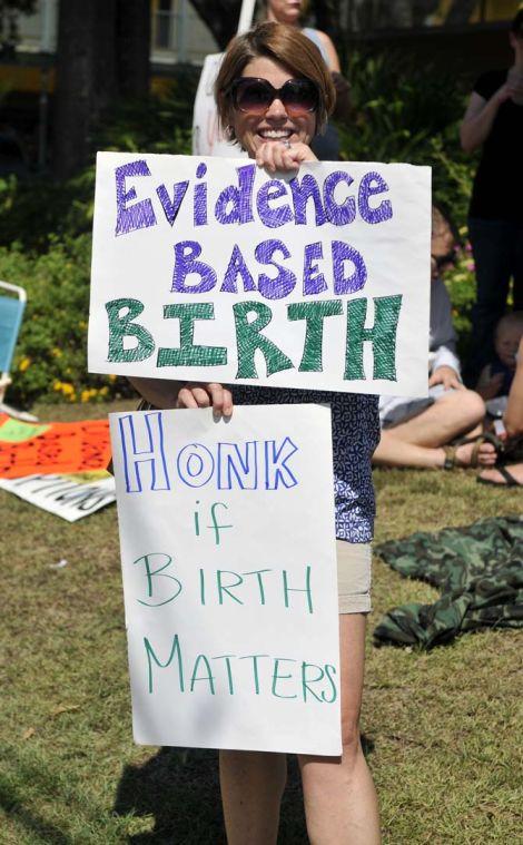 Susan Shelton, an instructor of nursing at ULL, stands holds up signs advocating better birthing options on September 2, 2013 during the Better Birth Rally at The Red Shoes on Government Street.