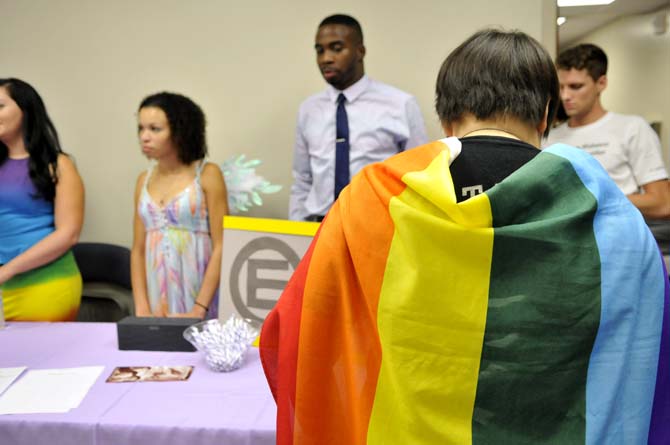 LSU Student Equality Project member, Katie Perry, shows her pride with a rainbow flag Thursday, Sept. 19, 2013 as they inform LSU students about the club at the Rainbow Rush Convention in the Women's Culture Center