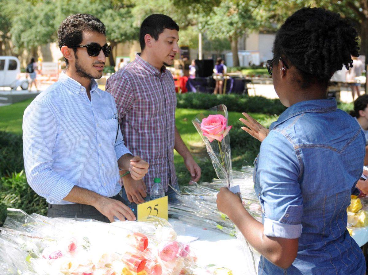 Saudi Club member Saud al Otibi gives roses to student Moriah Graham Wednesday, Sept. 11, 2013, at the Student Involvement Fair in Free Speech Alley.