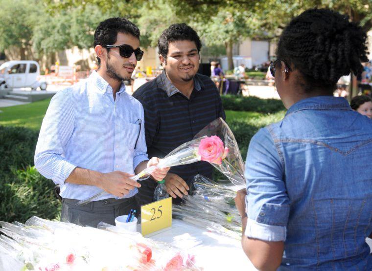 Saudi Club members Saud al Otibi and Ammar Banafea give roses to student Moriah Graham Wednesday, Sept. 11, 2013, at the Student Involvement Fair in Free Speech Alley.