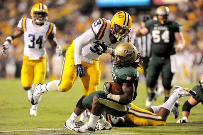 LSU junior defensive end Jermauria Rasco tackles UAB junior runningback Darrin Reaves Sept. 7, 2013 during the 56-17 victory against UAB in Tiger Stadium.