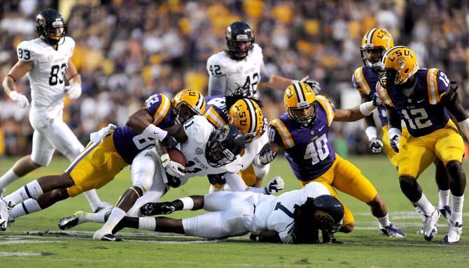 LSU senior wide reveiver James Wright (82), senior line backer Tahj Jones (58), and freshman line backer Duke Riley (40) take down a Kent St. ball carrier.