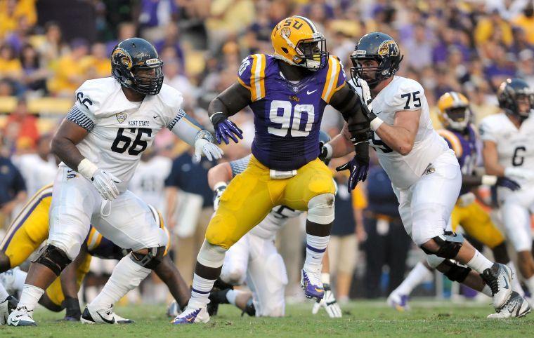 LSU junior defensive tackle Anthony Johnson (90) weaves between Kent State sophomore Anthony Pruitt and senior offensive lineman Phil Huff (75) on Saturday night in the Tigers' 45-13 victory against Kent State.