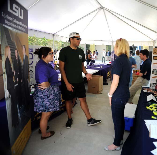 Students receive information about connecting with the School of Business from Shane Bickham (right) and Maura Toups (left) at the Jumping into Business event in the Business Education Complex Courtyard.