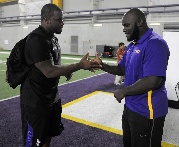 Anthony Johnson and Ego Ferguson shake hands Monday, Sept. 23, 2013 in the Charles McClendon Football Practice Facility.