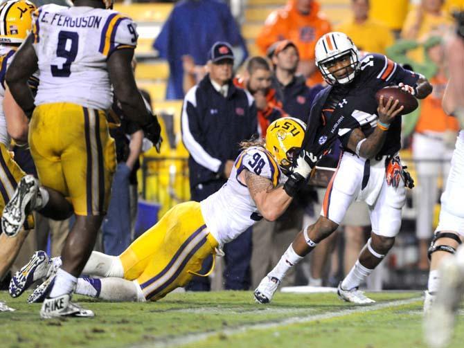 LSU junior defensive end Jordan Allen (98) attempts to bring down Auburn junior quarterback Nick Marshall (14) Saturday, Sept. 21, 2013 during the Tigers' 35-21 victory against Auburn in Tiger Stadium.