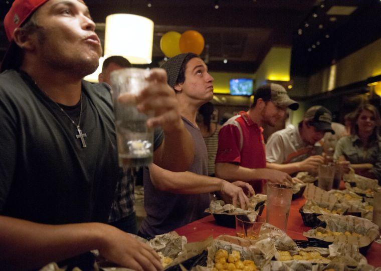 Competitors in the Bar Louie Rock The Tot competition look to the heavens as they eat tater tots Thursday night, Sept. 19, 2013.