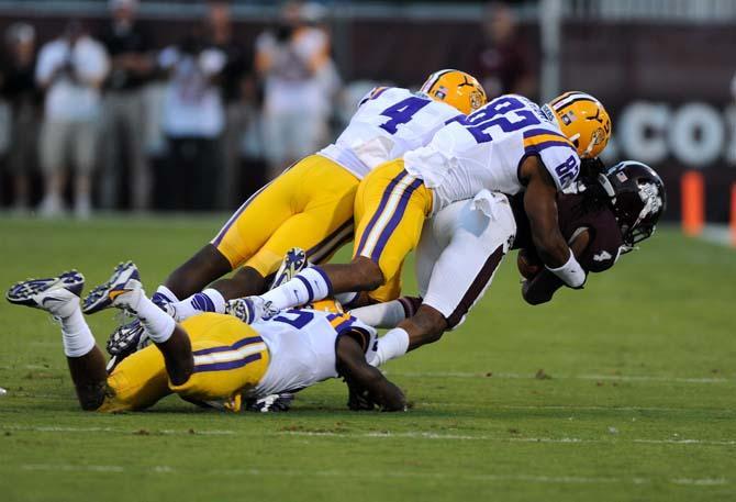 LSU senior running back Alfred Bkue (4) and senior wide receiver James Wright (82) tackle Mississippi State junior wide receiver Jameon Lewis (4) on Saturday Oct. 5, 2013 during the 59-26 victory against Mississippi State in Davis Wade Stadium.