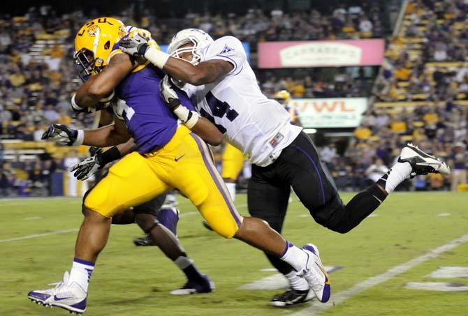 LSU junior running back Terrence Magee (14) runs past Furman defenders Saturday, Oct. 26, 2013, during the Tigers' 48-16 win against Furman in Tiger Stadium.