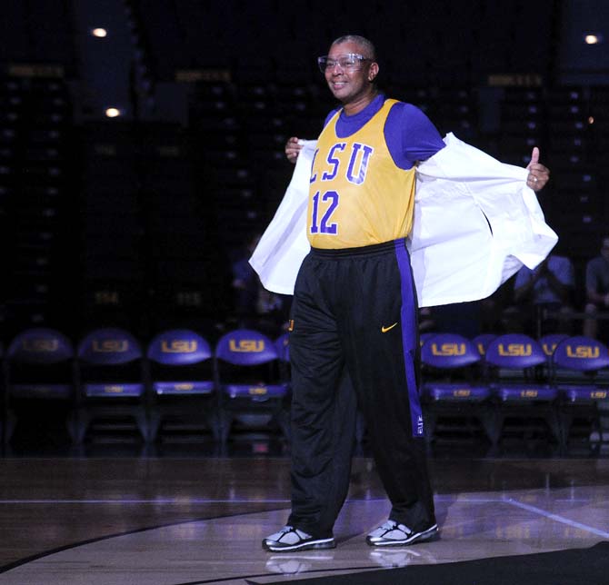 LSU men's basketball head coach Johnny Jones takes off a lab coat to reveal a jersey Thursday during Bayou Madness in the PMAC