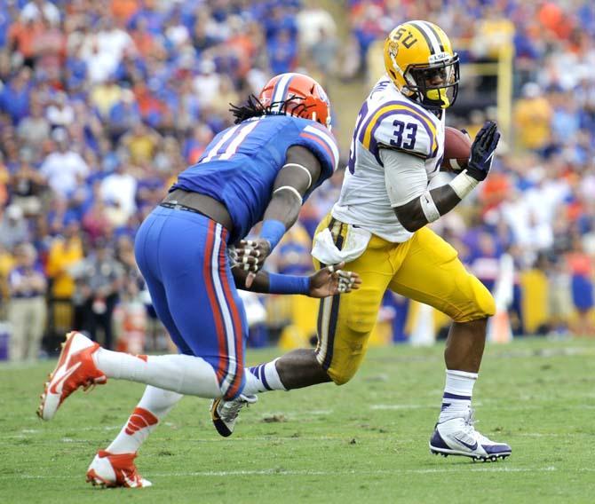 LSU sophomore running back Jeremy Hill (33) attempts to maneuver around Florida junior linebacker Neiron Ball (11) Saturday, Oct. 12, 2013 during the Tigers' 17-6 victory against the Gators in Tiger Stadium.