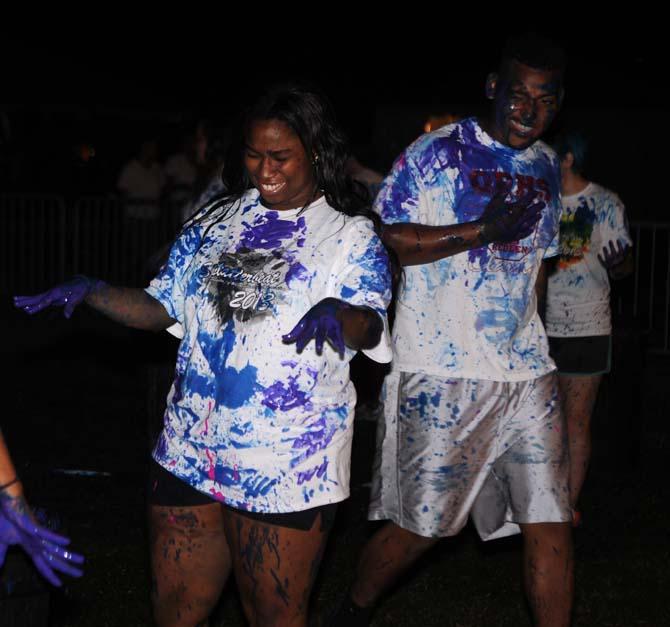 Two LSU students flinch after having paint sprayed on them on Monday, October 21, 2013, during the Splatterbeat homecoming week event on the Parade Ground.