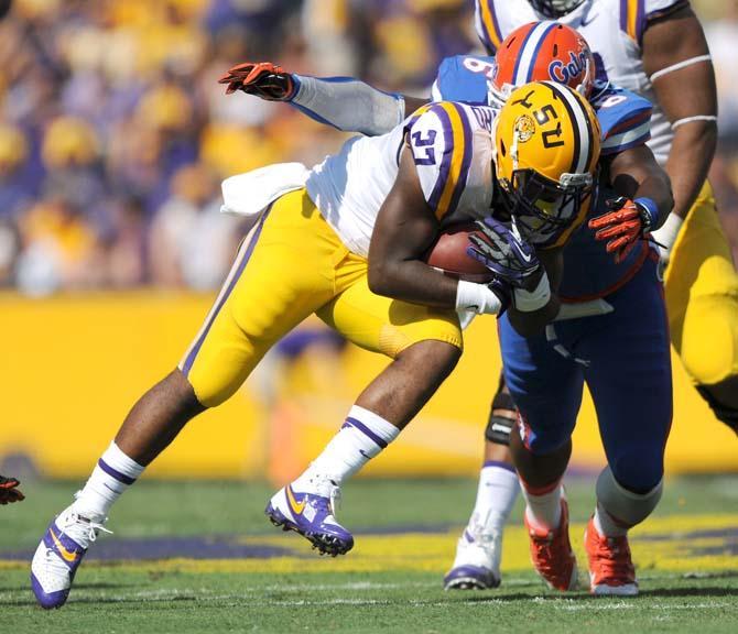 LSU junior running back Kenny Hilliard (27) attempts to maneuver past Florida sophomore defensive lineman Dante Fowler Jr. (6) Saturday, Oct. 12, 2013 during the Tigers' 17-6 victory against the Gators in Tiger Stadium.