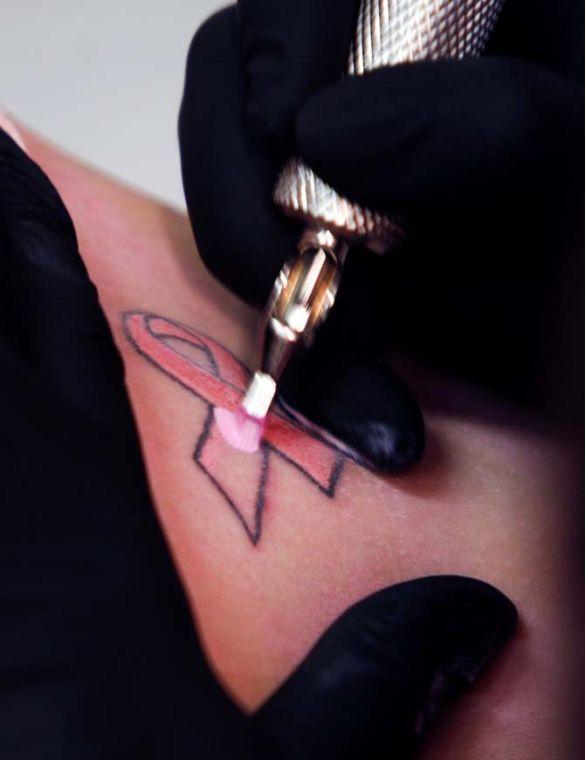 Corey Conway, of Owl's Head, Maine, gets a tattoo in the shape of the pink ribbon that is the icon for breast cancer at a shop in Augusta, Maine, on Wednesday, Dec. 2, 2009. Conway's mother, Mary Rapose, of Owl's Head, has been diagnosed with breast cancer and family members are showing their support by getting tattoos with the classic pink ribbon icon.(AP Photo/Pat Wellenbach)