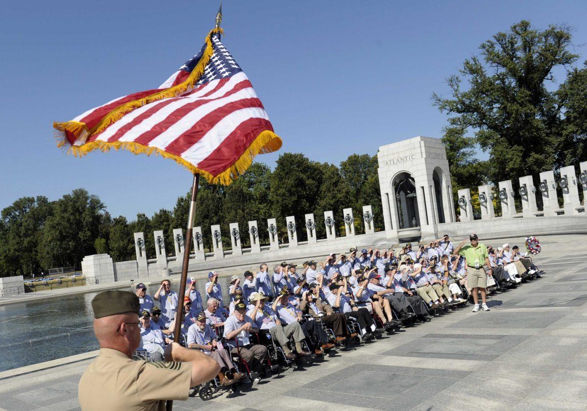 World War II veterans from the Chicago area salute as the colors are presented at the World War II Memorial in Washington, Wednesday, Oct. 2, 2013. This group of veterans came to Washington for the day just to see the memorial. It was an act of civil disobedience that marked the fact some barriers nor a government shutdown would keep a group of World War II veterans from visiting the monument erected in their honor. (AP Photo/Susan Walsh)