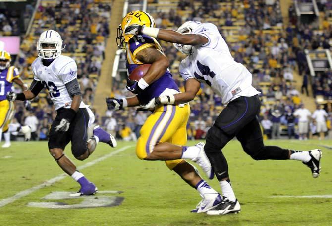 LSU junior running back Terrence Magee (14) runs past Furman defenders Saturday, Oct. 26, 2013, during the Tigers' 48-16 win against Furman in Tiger Stadium.