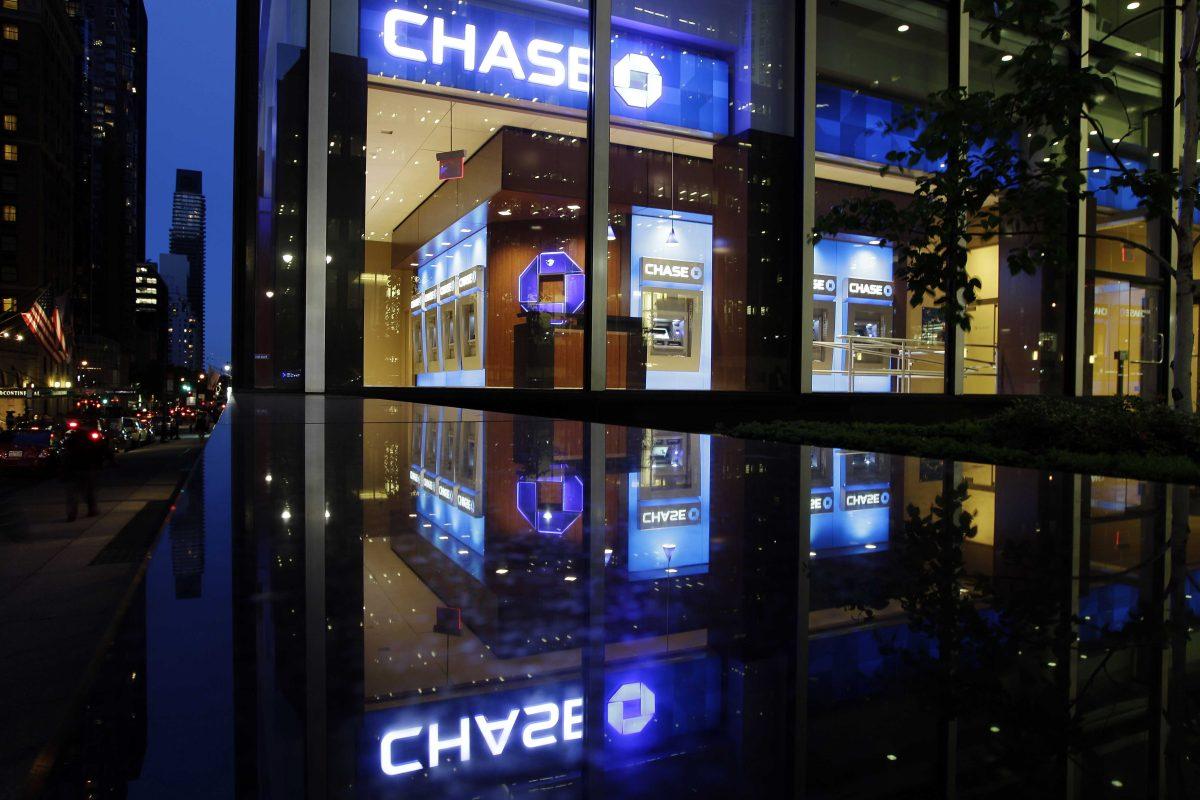 FILE - In this Thursday, May 10, 2012, file photo, automobiles pass a JP Morgan Chase building in New York. JPMorgan said Friday, Oct. 25, 2013, that it has agreed to pay $5.1 billion to resolve claims that it misled Fannie Mae and Freddie Mac about risky mortgage securities it sold them before the housing market collapsed. (AP Photo/Frank Franklin II, File)