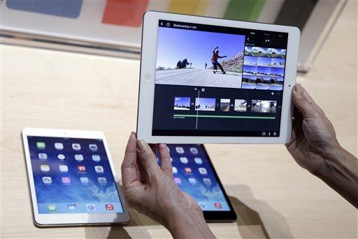 An Apple employee holds up the new iPad Air on Tuesday, Oct. 22, 2013, in San Francisco. Apple unveiled a new, thinner, lighter tablet called the "iPad Air" along with a slew of new Macs Tuesday at an event in San Francisco. The iPad Air weighs just 1 pound, compared with 1.4 pounds for the previous version. (AP Photo/Marcio Jose Sanchez)