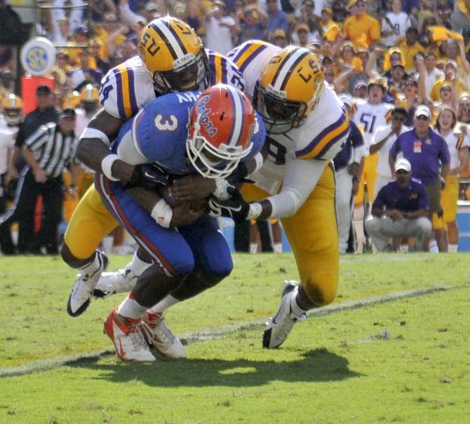 LSU sophomore safety Micah Eugene (34) and LSU senior linebacker Lamin Barrow (18) tackle Florida junior quarterback Tyler Murphy (3) on Saturday, Oct. 12, 2013 during the Tigers' 17-6 victory against the Gators in Tiger Stadium.