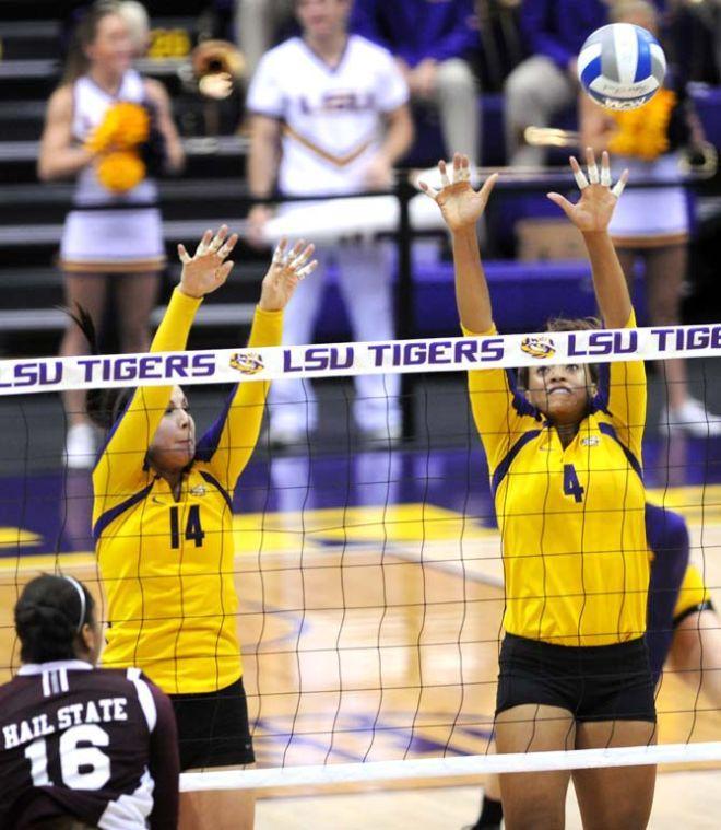 LSU junior setter Malorie Pardo (14) and senior middle blocker Desiree Elliott (4) attempt to block a scoring attempt from Mississippi State player Sunday, Oct. 13, 2013 during the Tigers' victory against the Bulldogs in the PMAC.