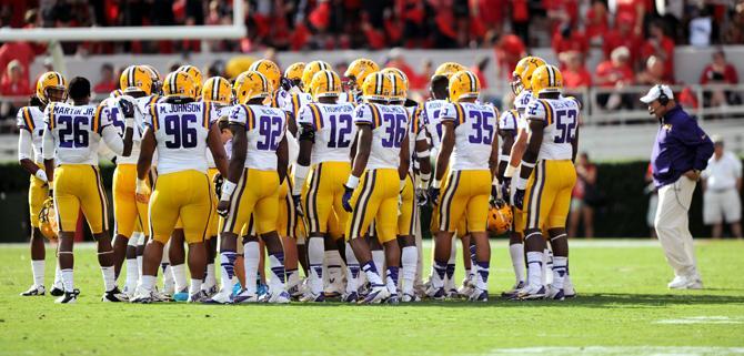 LSU head football coach Les Miles walks to meet his team during a time out Saturday, Sept 28, 2013 after UGA's 44-41 victory against the Tigers in Sanford Stadium.