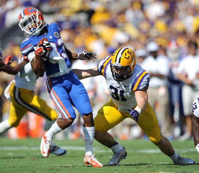 LSU junior linebacker D.J. Welter (31) attempts to bring down Florida junior running back Mack Brown (33) Saturday, Oct. 12, 2013 during the Tigers' 17-6 victory against the Gators in Tiger Stadium.