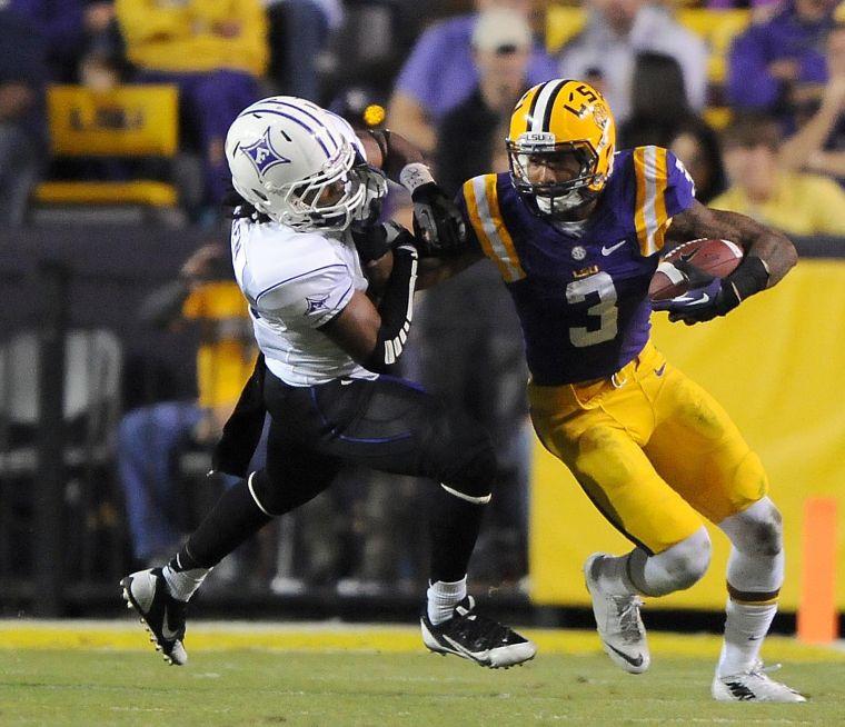 LSU junior wide receiver Odell Beckham Jr. (3) stiff arms a Furman defender Saturday night, Oct. 26, 2013 during the Tigers' 48-16 win against Furman in Tiger Stadium.