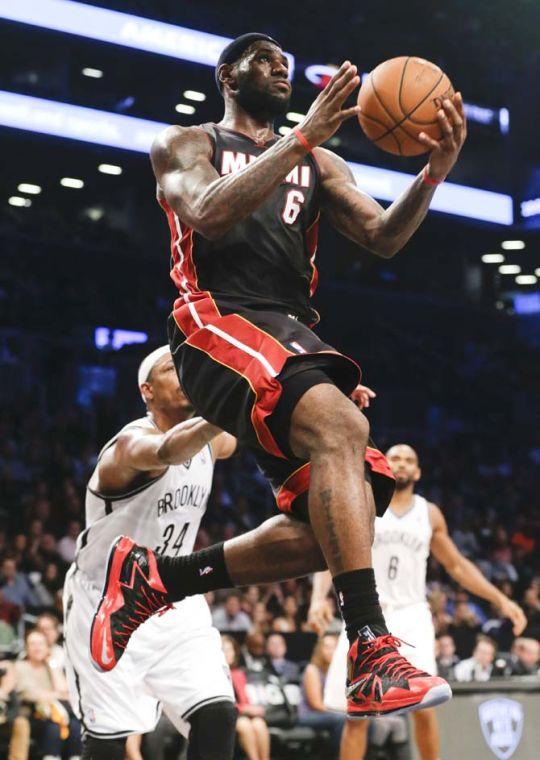 Miami Heat's LeBron James (6) drives past Brooklyn Nets' Paul Pierce (34) during the second half of an NBA basketball game Thursday, Oct. 17, 2013 in New York. The Nets won the game 86-62. (AP Photo/Frank Franklin II)