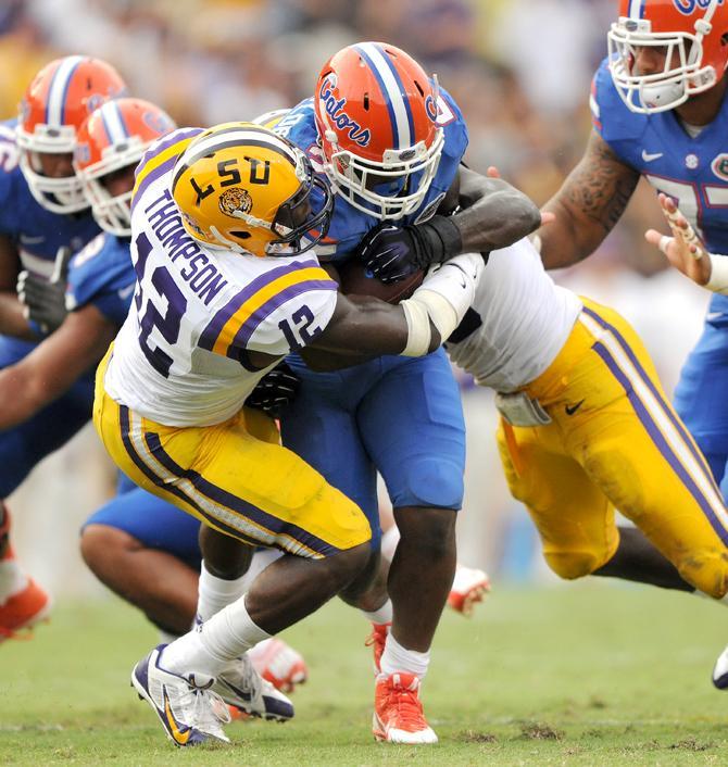 LSU sophomore safety Corey Thompson (12) tackles Florida freshman running back Kelvin Taylor (21) during the Tigers' 17-6 victory against the Gators in Tiger Stadium.