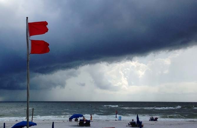 Red flags warn swimmers to stay out of the Gulf of Mexico as a squall from Tropical Storm Karen moves offshore at Gulf Shores, Ala., on Saturday, Oct. 5, 2013. The beaches remained open, but authorities said dangerous underwater rip currents made the waters too dangerous to enter. (AP Photo/Jay Reeves)