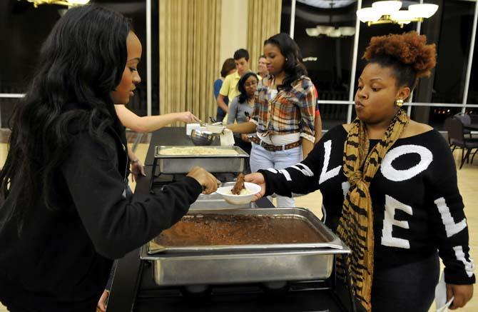 Business management junior Chenice Samuel is served red beans and rice after being randomly selected as a middle class person at the 2013 Oxfam Hunger Banquet Wednesday, Oct. 23, 2013 in the Student Union.