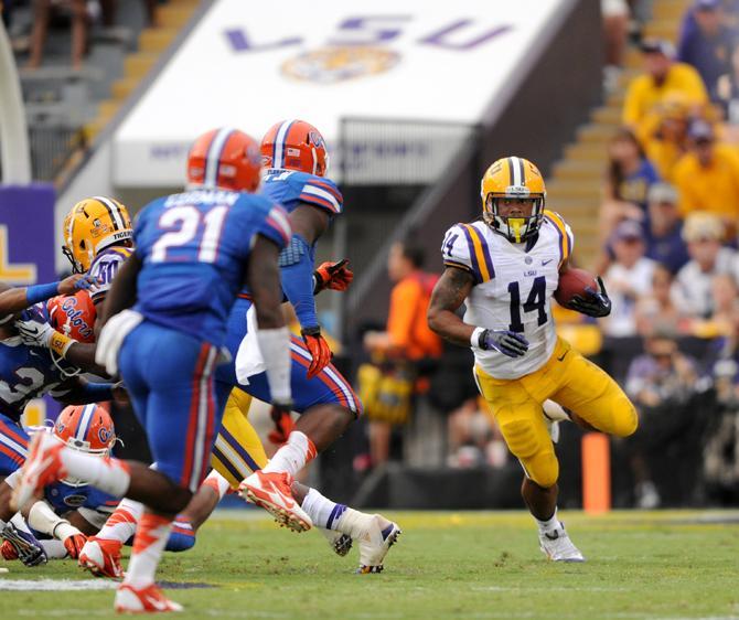 LSU junior running back Terrence Magee (14) rushes toward the first down during the 17-6 victory against Florida in Tiger Stadium.