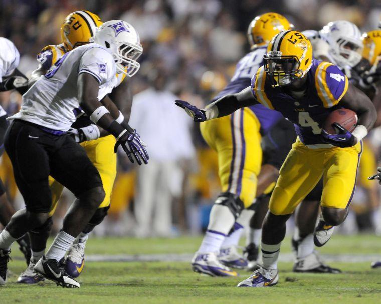 LSU senior running back Alfred Blue (4) dodges Furman defenders Saturday night, Oct. 26, 2013 during the Tigers' 48-16 win against Furman in Tiger Stadium.