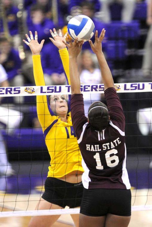 LSU junior setter Malorie Pardo (14) attempts to block a scoring attempt from Mississippi State senior outside hitter Dani McCree (16) Sunday, Oct. 13, 2013 during the Tigers' victory against the Bulldogs in the PMAC.