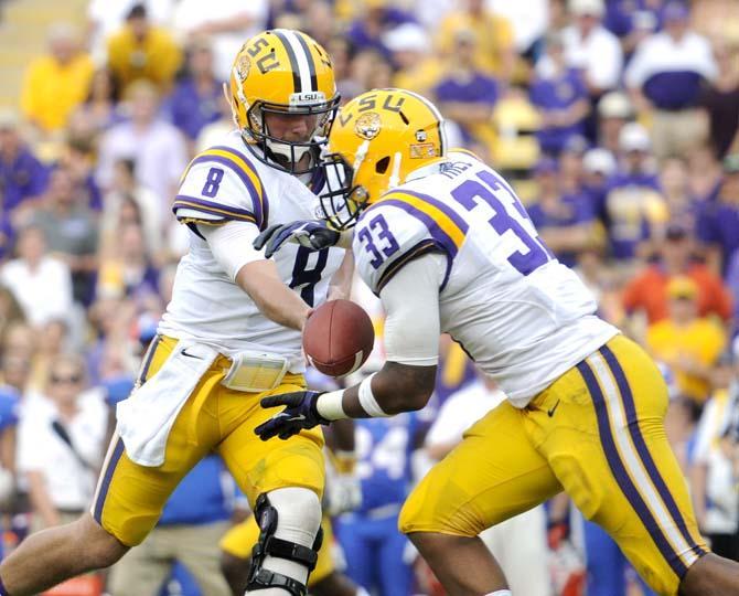 LSU senior quarterback Zach Mettenberger (8) hands the football off to sophomore running back Jeremy Hill (33) Saturday, Oct. 12, 2013 during the Tigers' 17-6 victory against the Gators in Tiger Stadium.