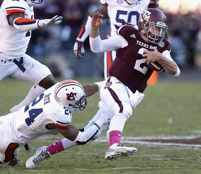 Texas A&amp;M quarterback Johnny Manziel (2) scrambles past Auburn defensive back Ryan Smith (24) during the third quarter of an NCAA college football game Saturday, Oct. 19, 2013, in College Station, Texas. Auburn won 45-41. (AP Photo/Bob Levey)