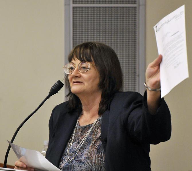 Judith Baker, author of "Me and Lee - How I came to know, love, and lose Lee Harvey Oswald, holds up a document at a symposium on Sat. Oct. 19, 2013 at Loyola University in New Orleans.