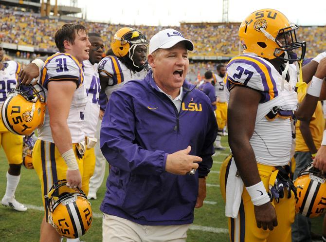 LSU head football coach Les Miles runs to join the team in the Alma Mater after the 17-6 victory against Florida in Tiger Stadium.