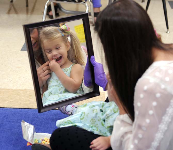 Speech Pathology graduate student Morgan Soike encourages Kate Worthington to move her tongue Monday, October 7, 2013 in Hatcher Hall.