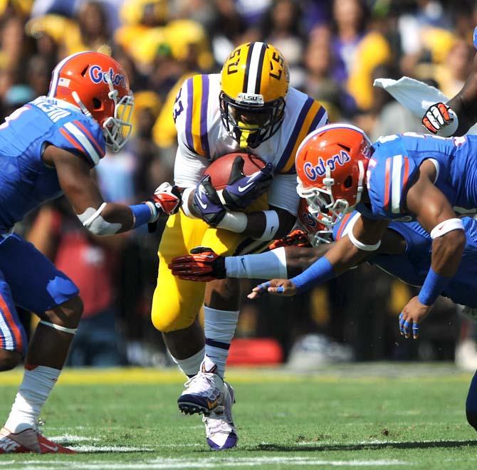 LSU sophomore running back Jeremy Hill (33) attempts to break the tackles of multiple Florida defenders Saturday, Oct. 12, 2013 during the Tigers' 17-6 victory against the Gators in Tiger Stadium.&#160;