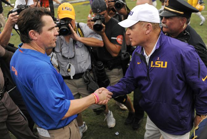 Florida head football coach Will Musechamp (left) and LSU head football coach Les Miles (right) meet for a handshake Saturday, Oct. 12, 2013 after the Tigers' 17-6 victory against the Gators in Tiger Stadium.