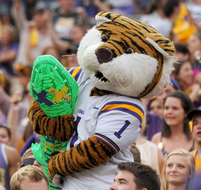 Mike the Tiger holds a dead gator Saturday, Oct. 12, 2013 during the Tigers' 17-6 victory against the Gators in Tiger Stadium.