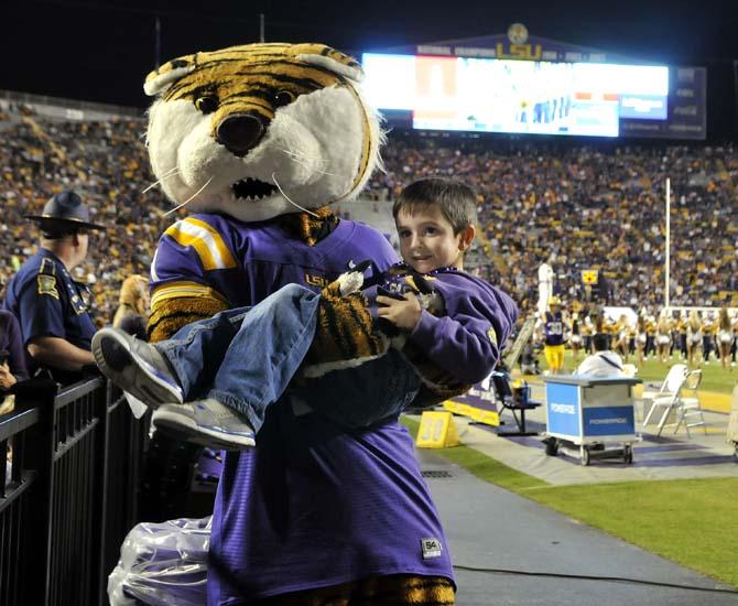 Mike the Tiger plays with a little Tigers' fan Saturday, Oct. 26, 2013, during the Tigers' 48-16 win against Furman in Tiger Stadium.