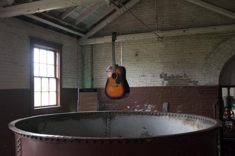 A guitar overhangs an inoperative water filter as part of UK artist Simon Whetham's set.